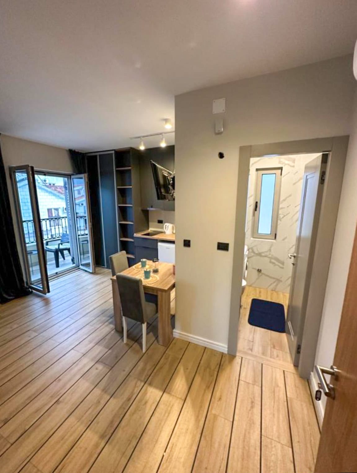 Modern living room with kitchen and access to the balcony in an apartment, Budva, Montenegro: bright interior, dining area.