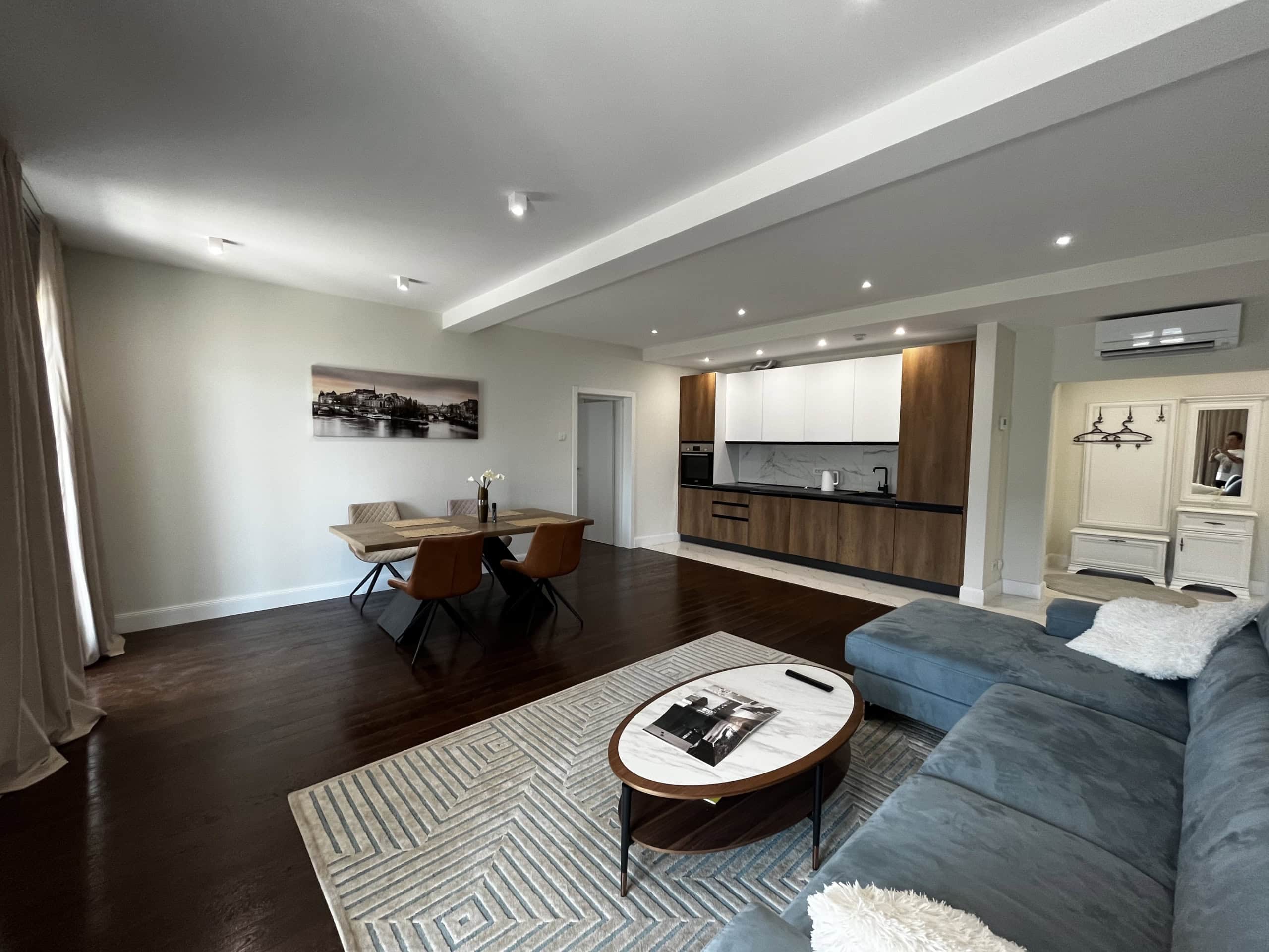 Modern living room with kitchen in Kumbor, Montenegro: a soft sofa, dining area, and stylish interior finishes.