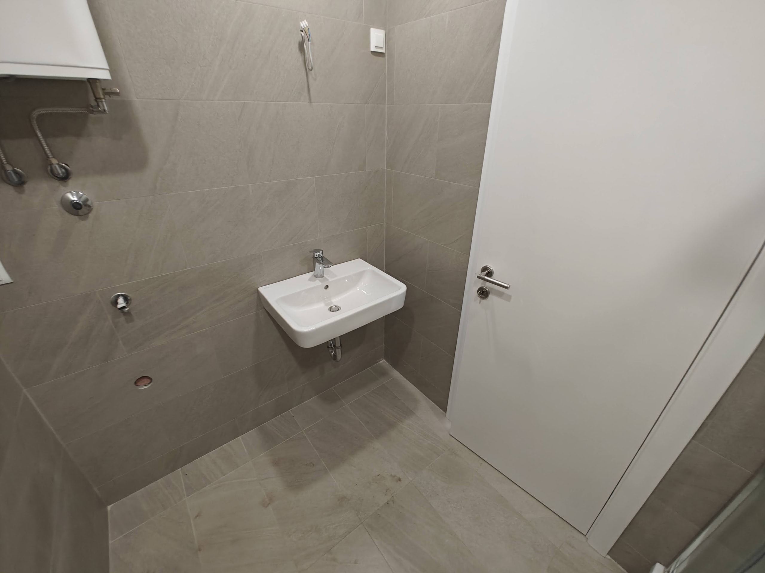 Modern bathroom with tiled finishes and a sink in an apartment, Budva, Montenegro.