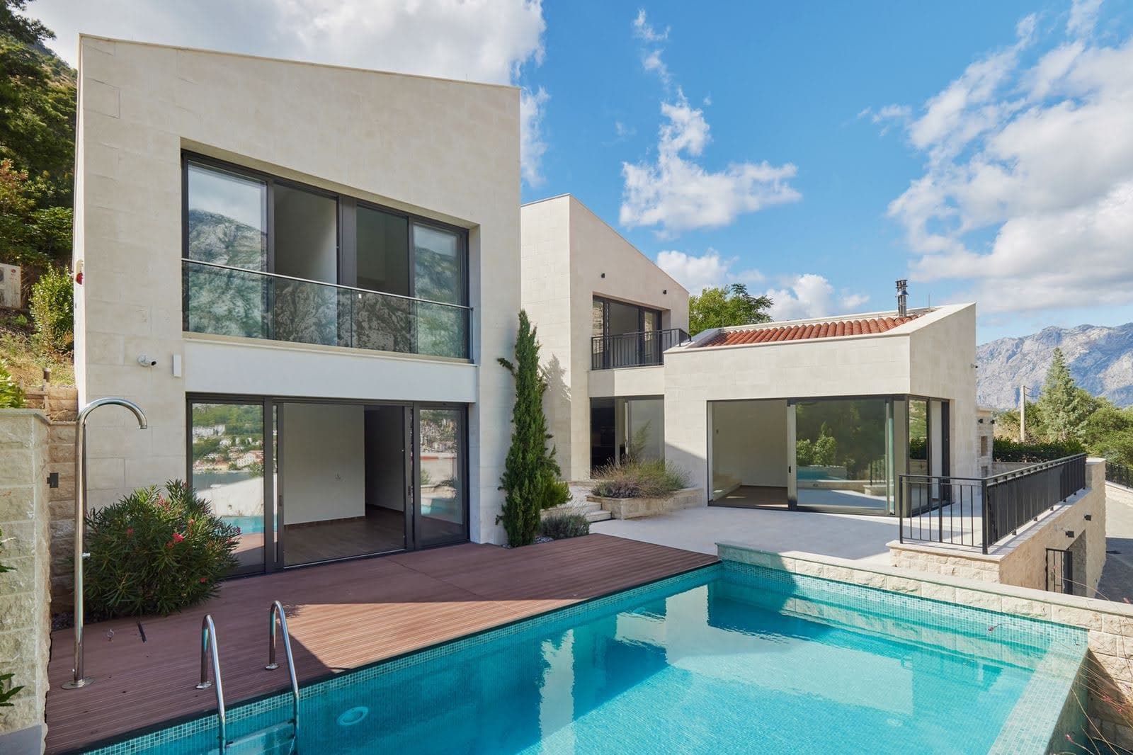 Modern villa with a pool and terrace in Prčanj, Montenegro: panoramic windows, stone finishes, and mountain views.
