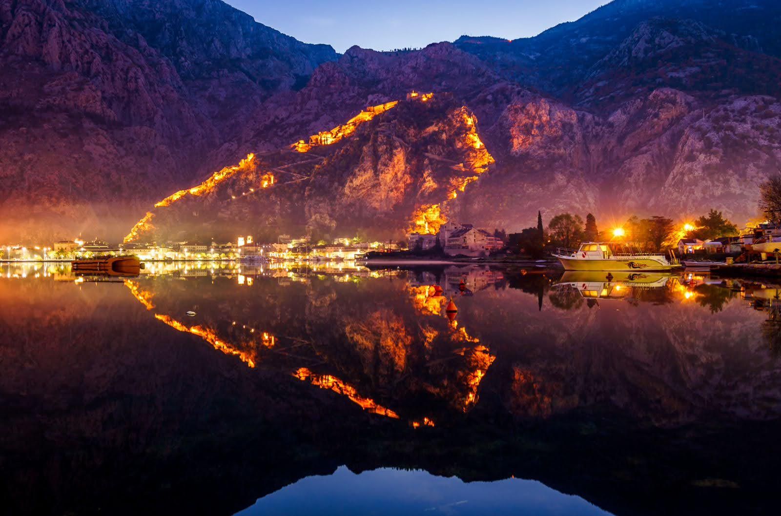 Evening view of the illuminated Kotor Fortress and bay in Prčanj, Montenegro: a villa with panoramic mountain and sea views.