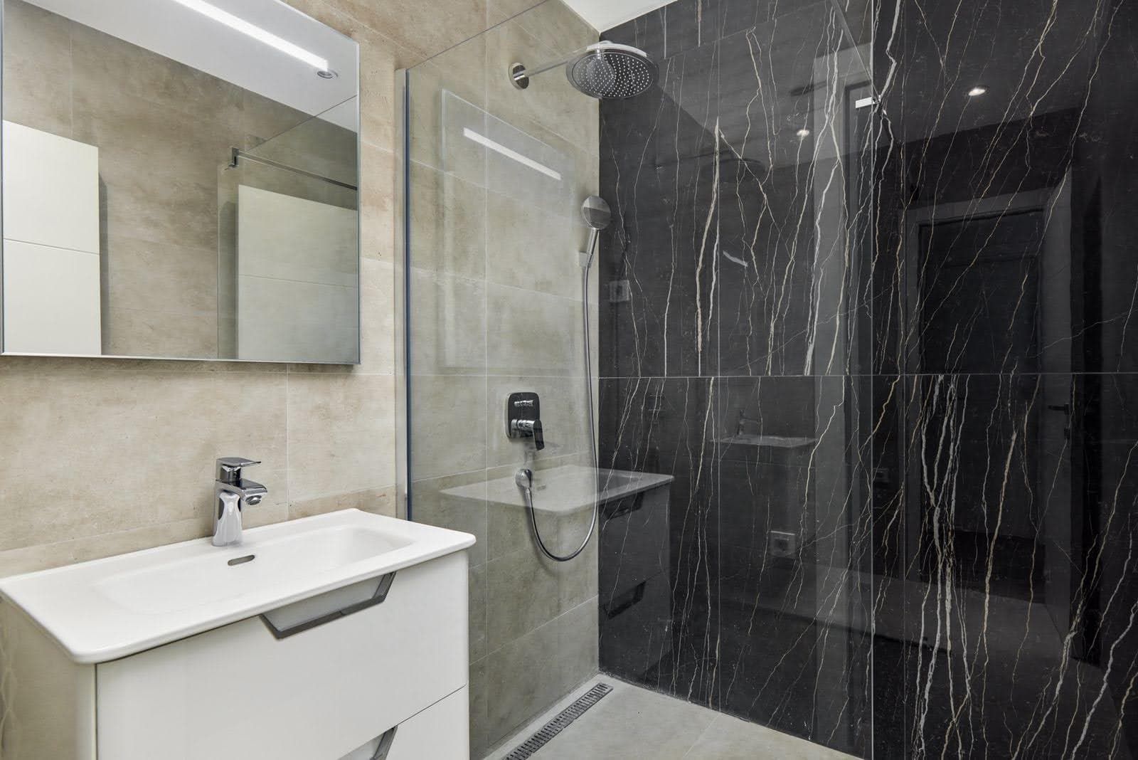 Modern bathroom with a shower cabin and black marble finishes in a villa in Prčanj, Montenegro.
