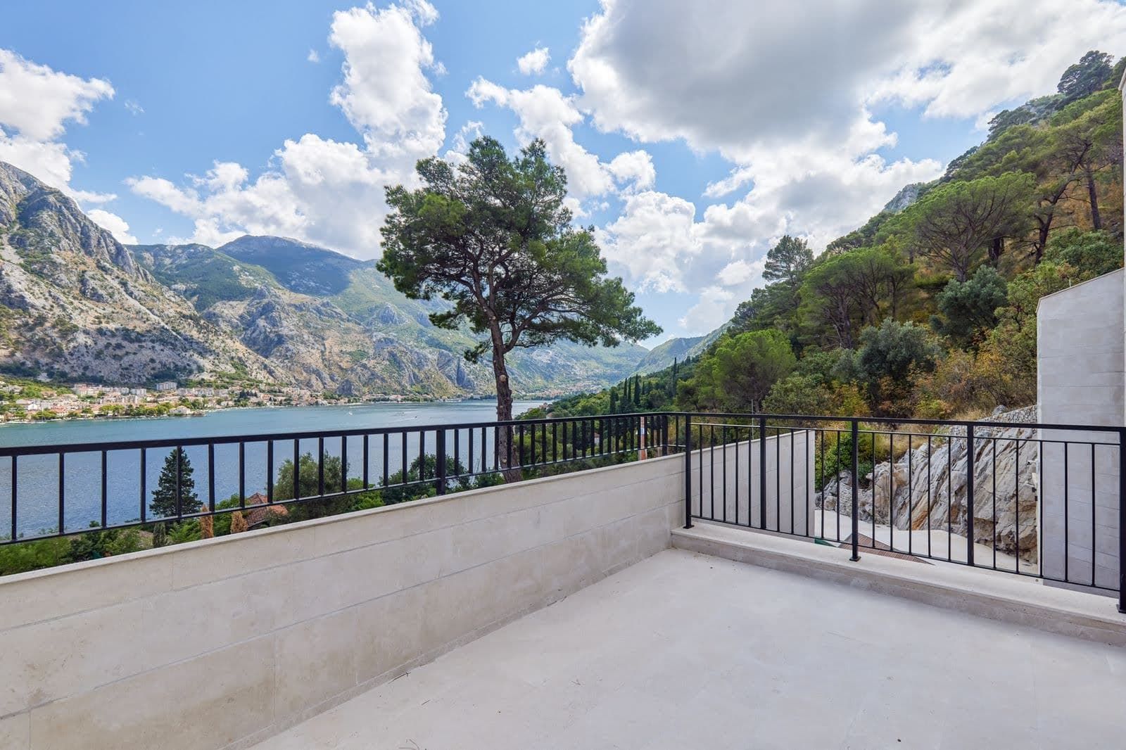 Spacious villa terrace in Prčanj, Montenegro, with panoramic views of Kotor Bay, the mountains, and stone finishes.