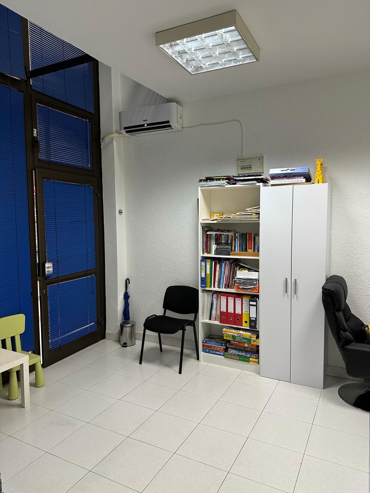 Office space in Bar, Montenegro: a bright office with a white cabinet, shelving unit, air conditioner, and panoramic door.