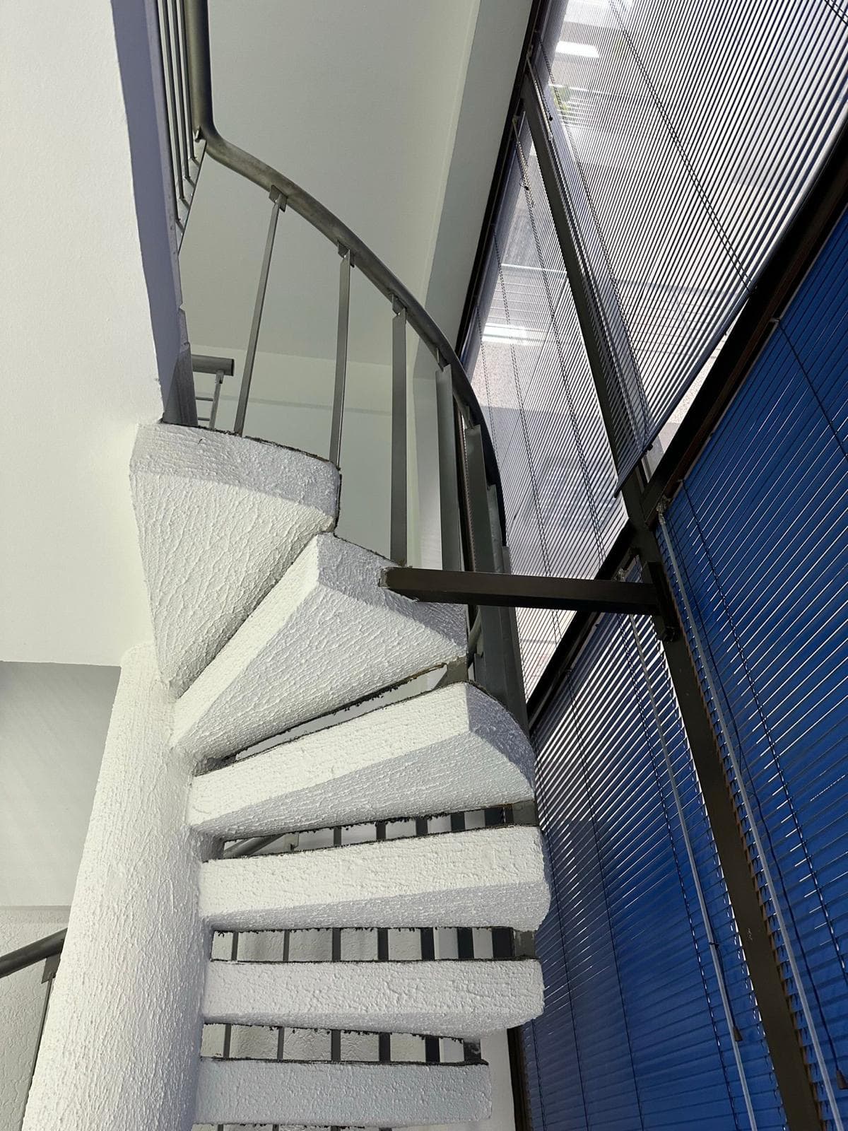 White spiral staircase in a modern office space, Bar, Montenegro, panoramic glazing with blinds.