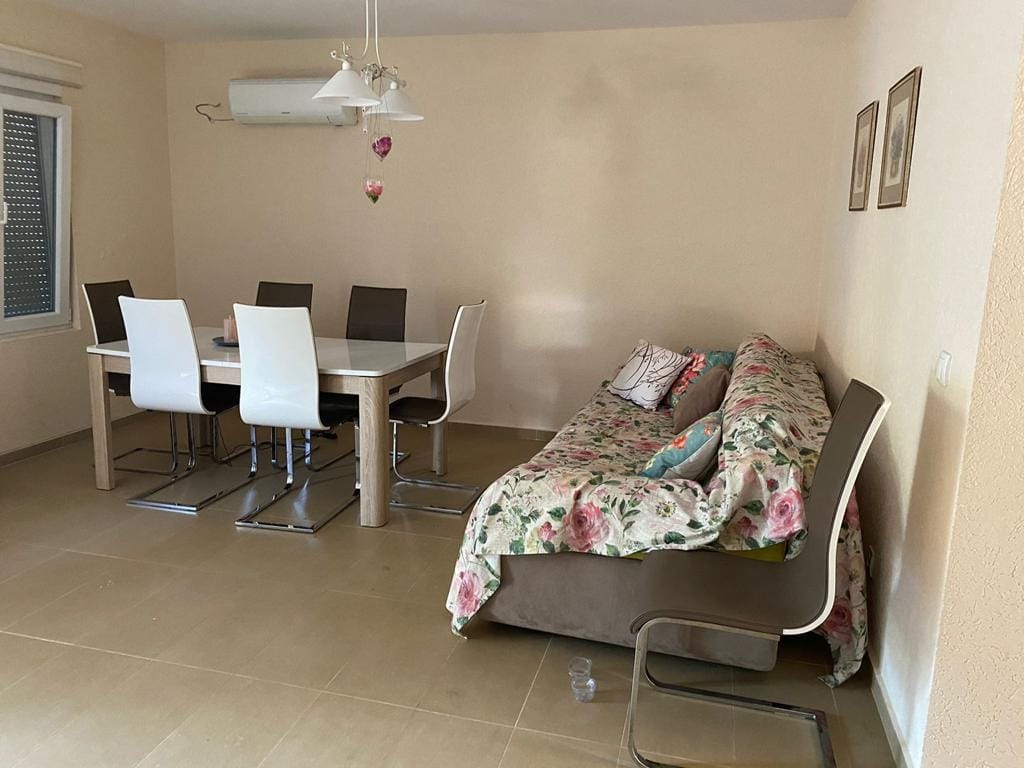 Living room with dining area and sofa in a house, Dobra Voda, Montenegro. Bright interior with modern furniture.
