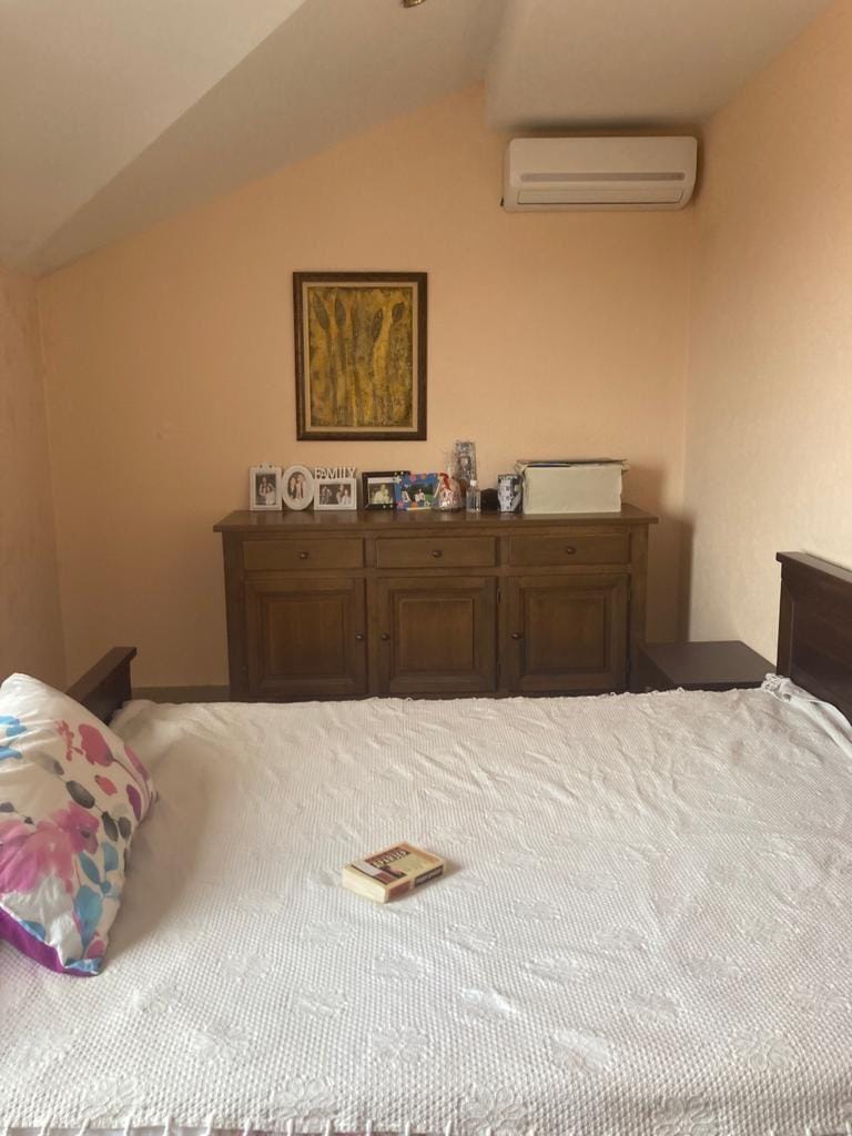 Cozy bedroom with a double bed and a wooden dresser in a house, Dobra Voda, Montenegro.