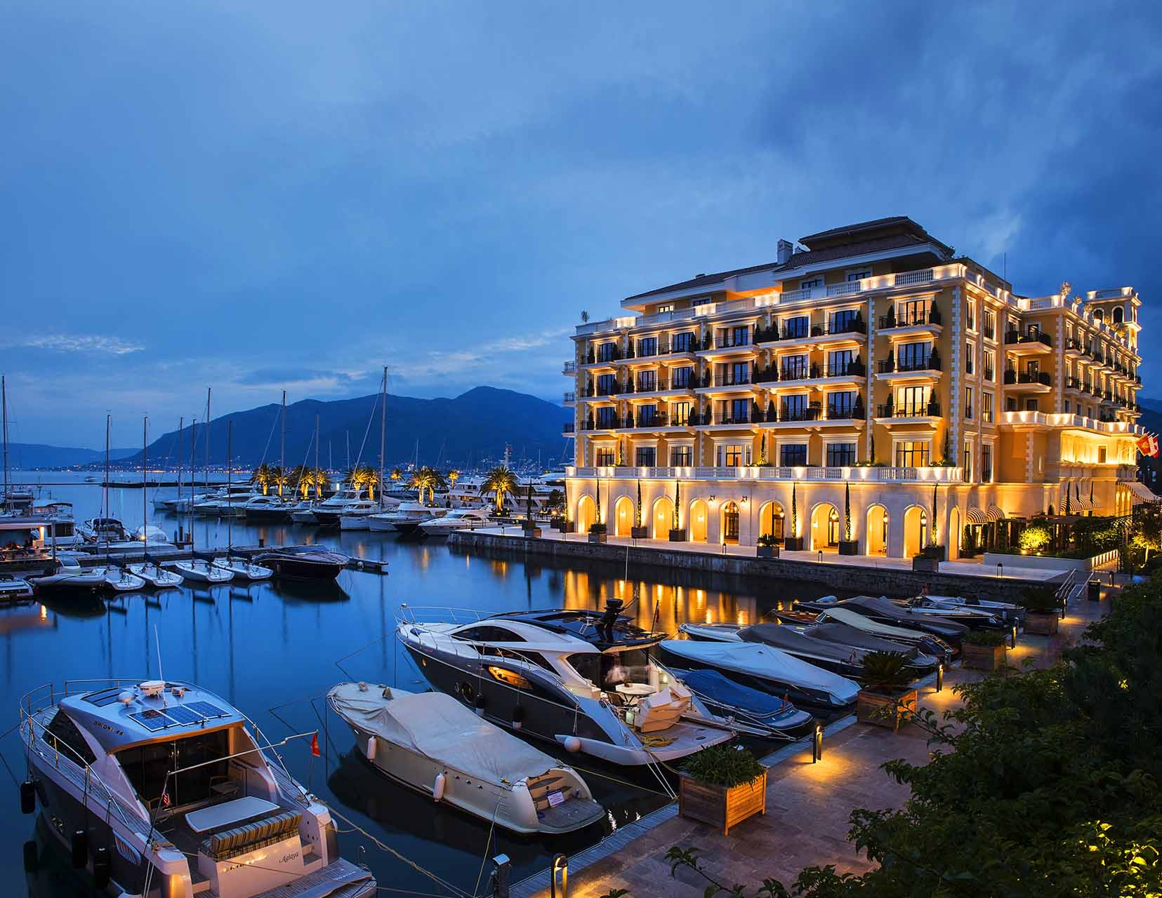 Luxury Regent Hotel in Porto Montenegro marina, Tivat, Montenegro: view of the illuminated building and yacht marina.