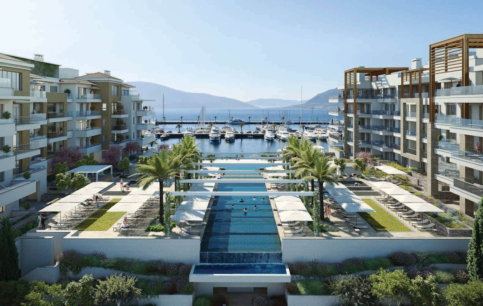 Luxury residential complex with a pool and views of the yacht marina in Tivat, Montenegro. Modern architecture and landscaping.
