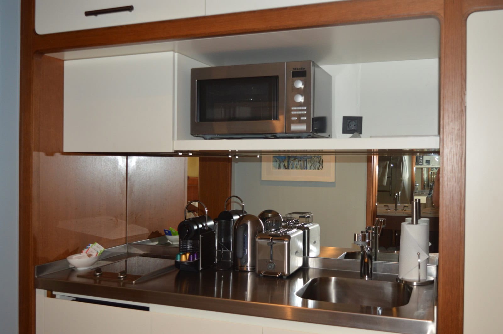 Kitchen area in a studio in Tivat, Montenegro: built-in Miele appliances, sink, coffee machine, and toaster on the countertop.