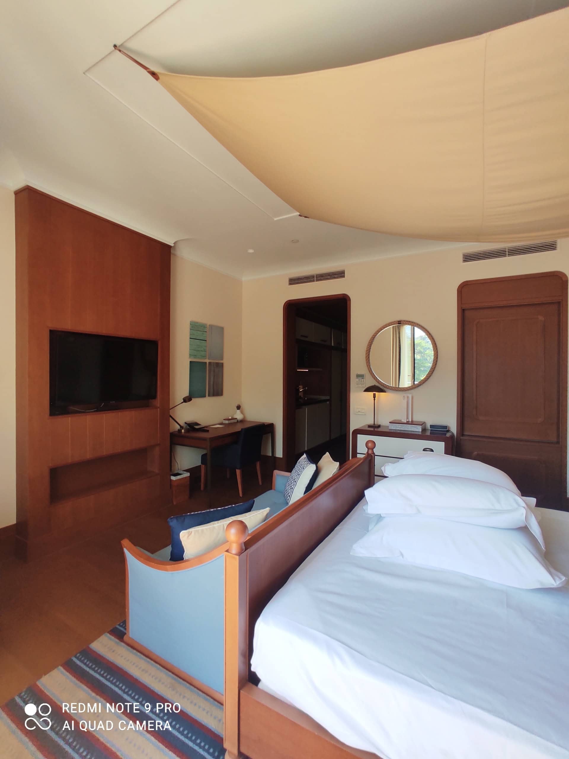 Bedroom interior in a studio in Tivat, Montenegro: double bed, wood finishes, TV area, and desk.