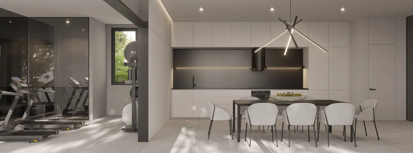 Modern kitchen and dining area adjacent to a home gym with treadmills visible behind a glass partition.