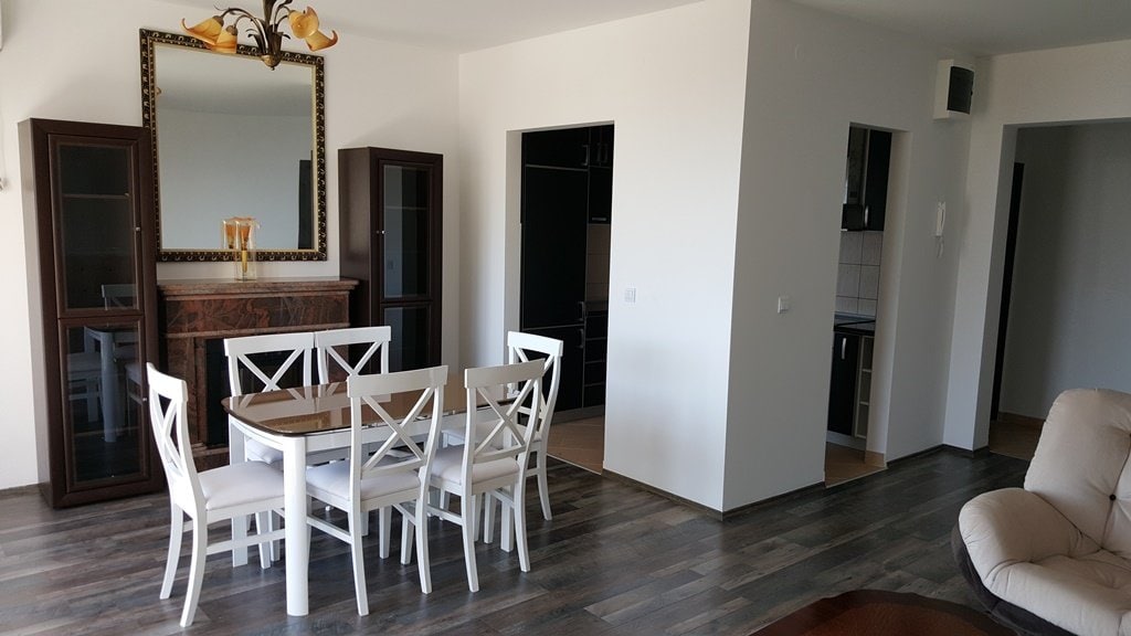 Living room with dining area, fireplace, and dark furniture in an apartment in Budva, Montenegro. Modern interior.