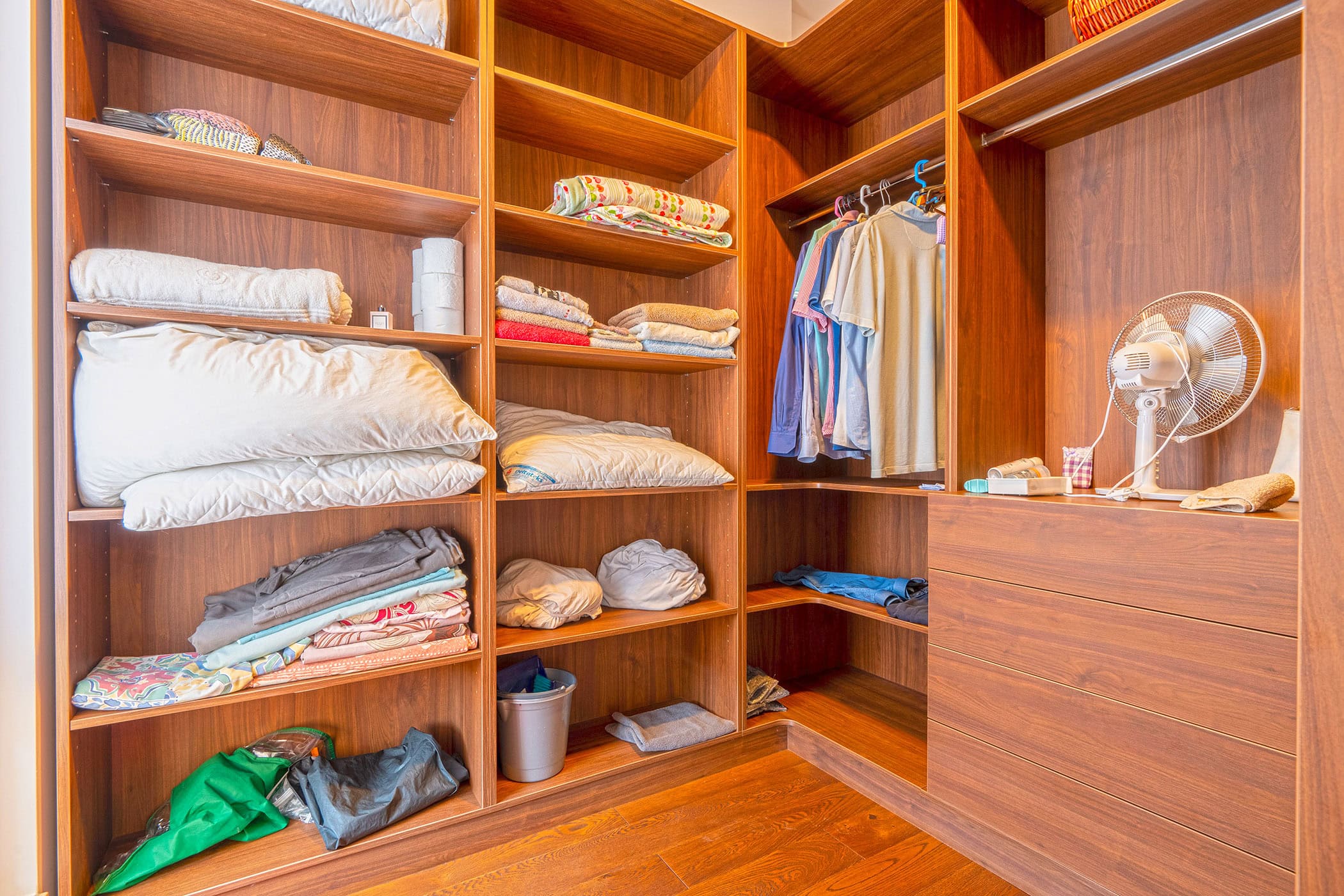 Spacious wooden walk-in closet with shelves and hangers in an apartment in Budva, Montenegro.