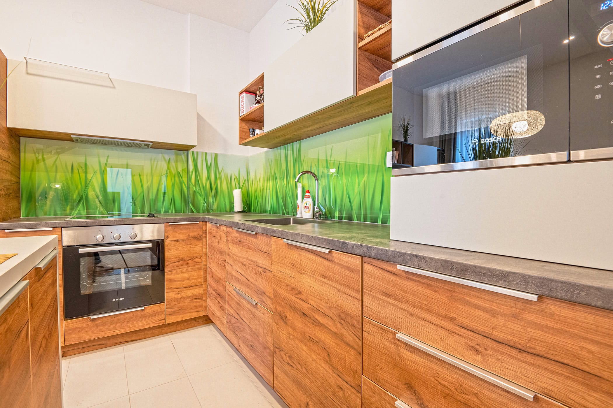 Modern kitchen with wooden fronts and a grass-pattern backsplash in an apartment in Budva, Montenegro, Bosch appliances.