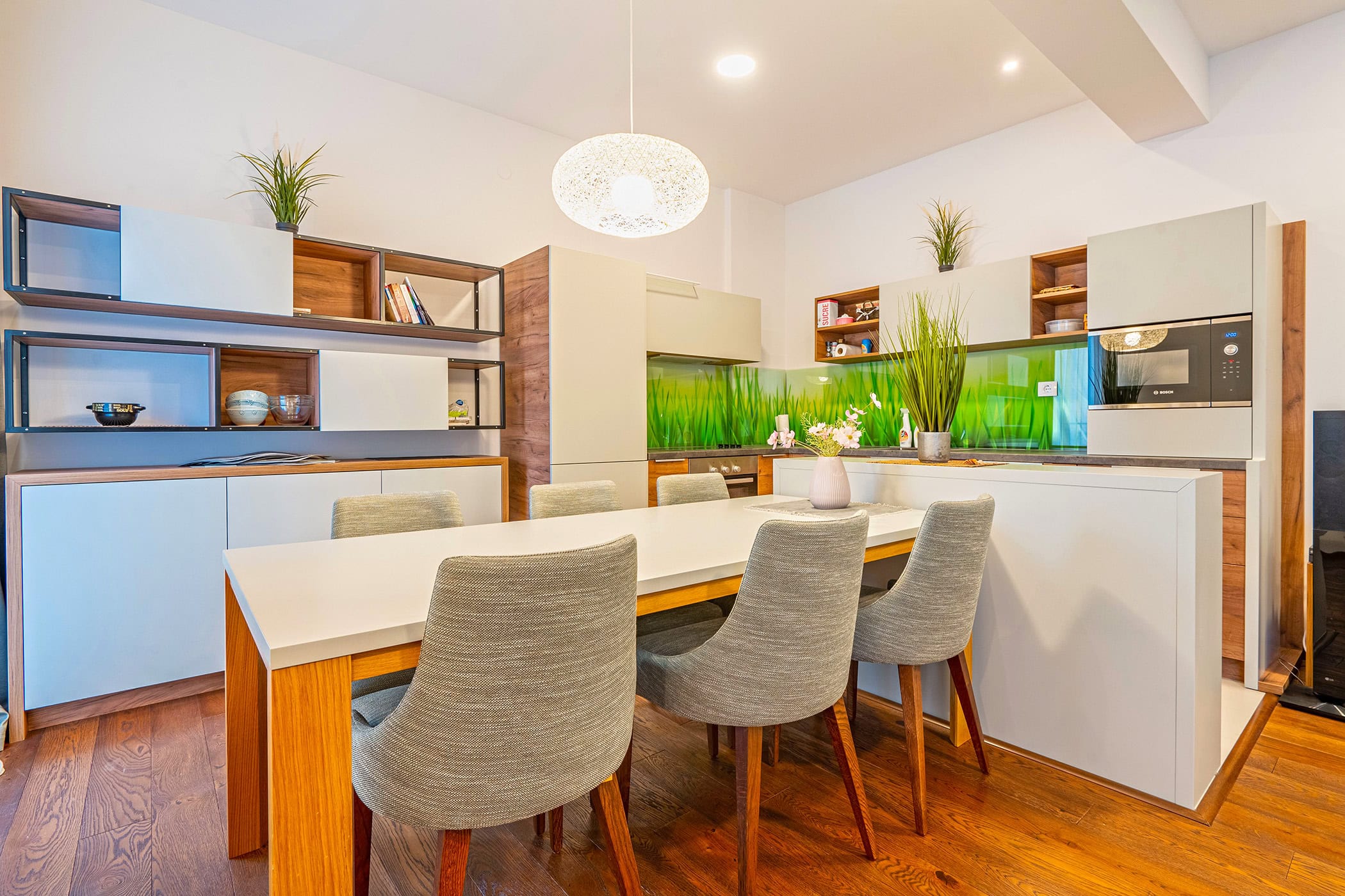 Modern kitchen-dining room in an apartment in Budva, Montenegro: light-colored cabinetry, dining table, and stylish decor.