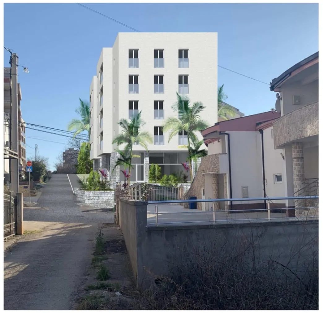 Exterior view of a white multi-story residential building seen from the street, surrounded by palm trees.