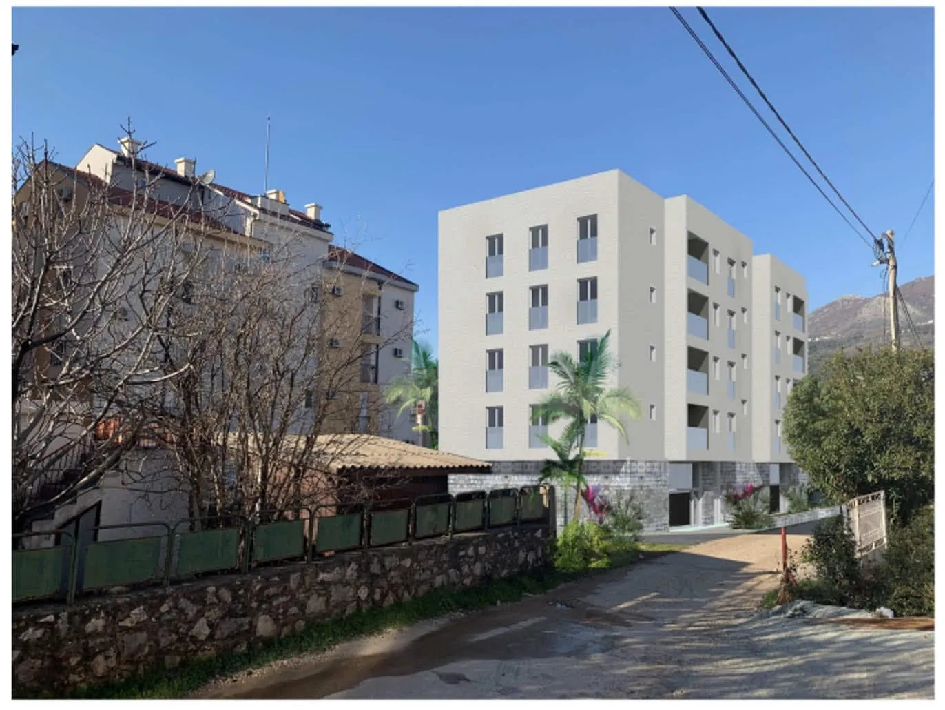 Exterior view of a modern white multi-story residential building set against mountains and an older structure.