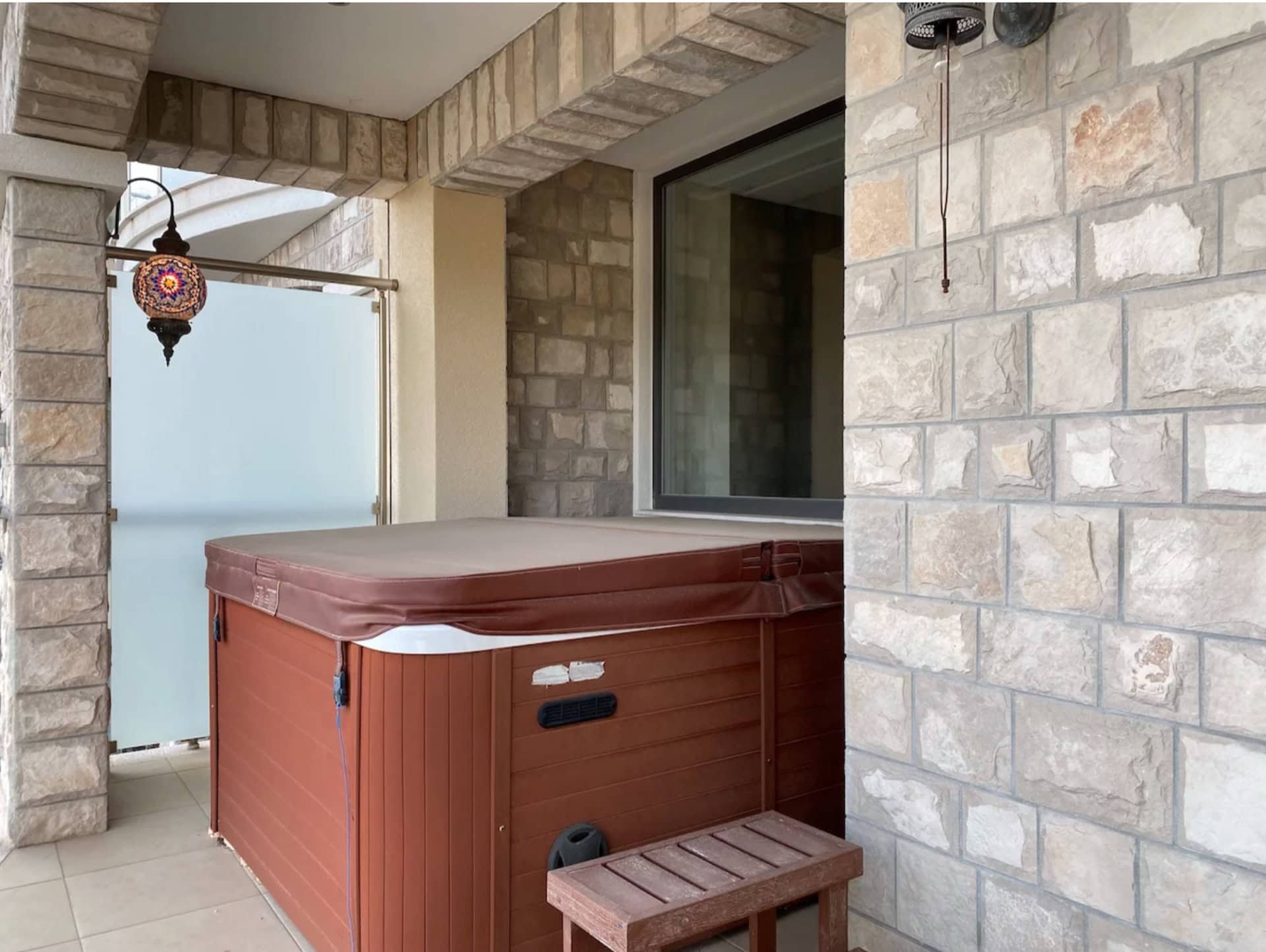 Jacuzzi on the apartment terrace in Bečići, Montenegro: natural stone finish and a stylish oriental lantern.