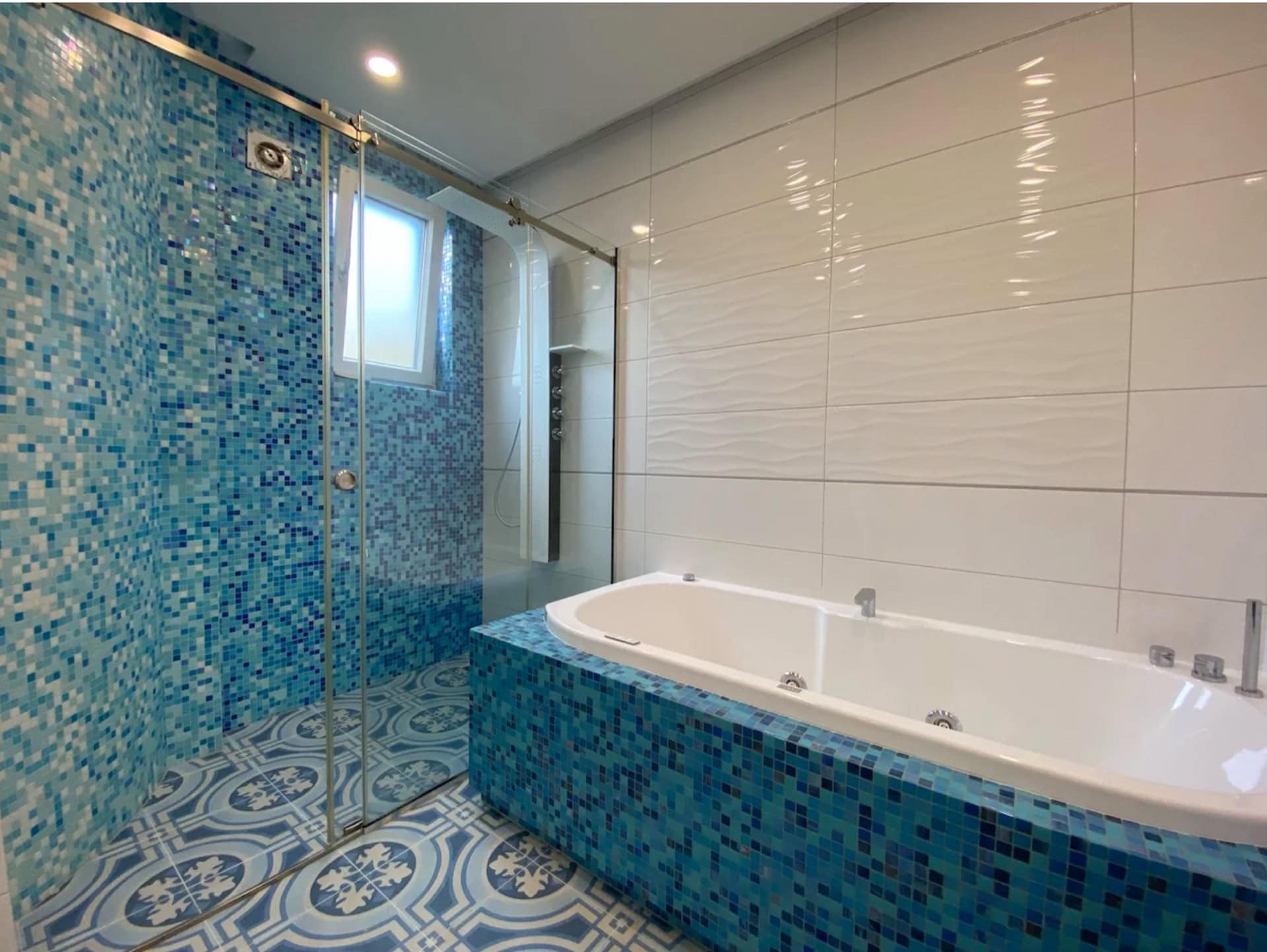 Modern bathroom with jacuzzi and shower cabin in an apartment in Bečići, Montenegro: finished with blue mosaic.
