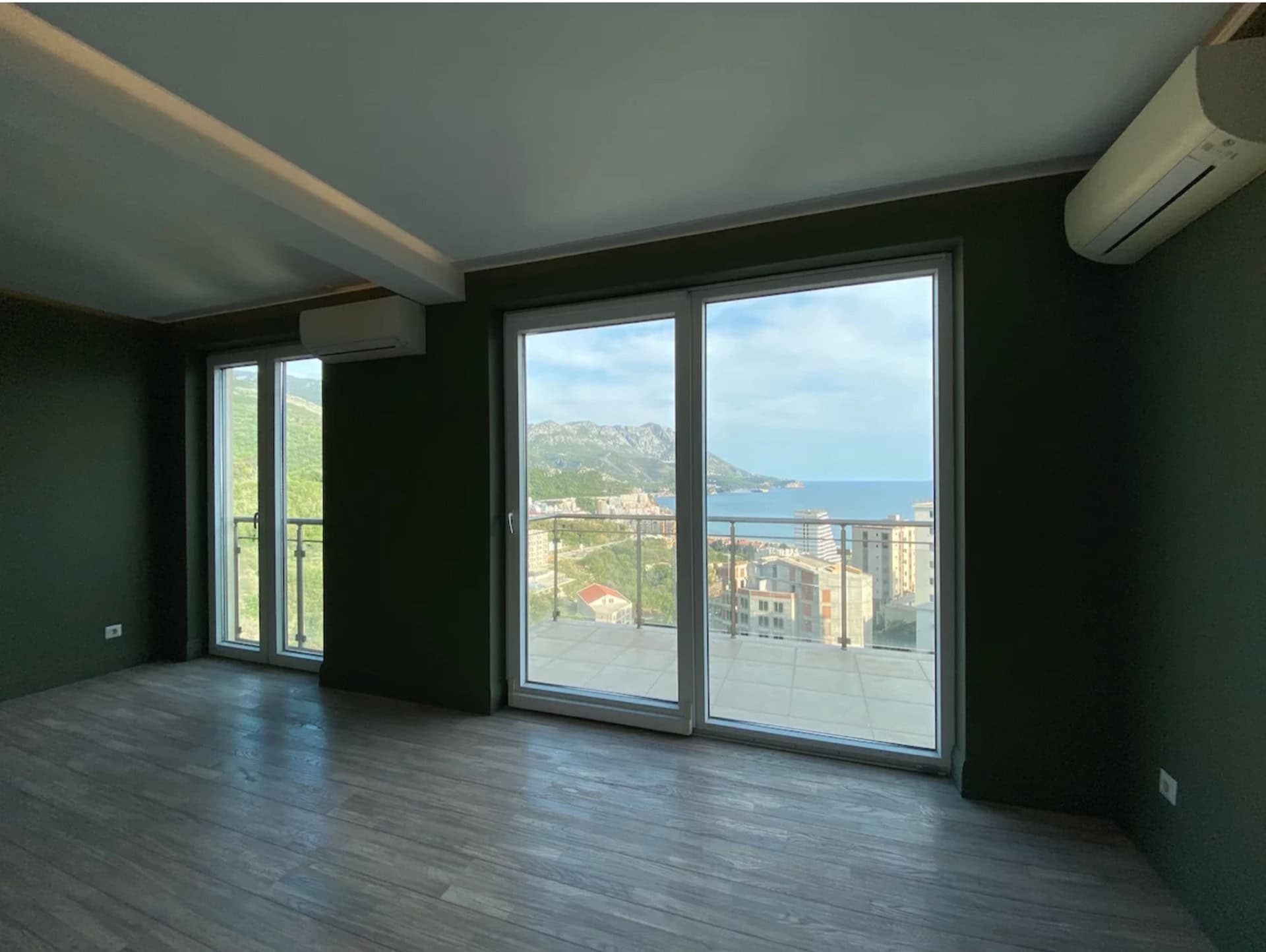 Living room with panoramic windows and sea view in an apartment, Becici, Montenegro: modern finishes and a terrace.