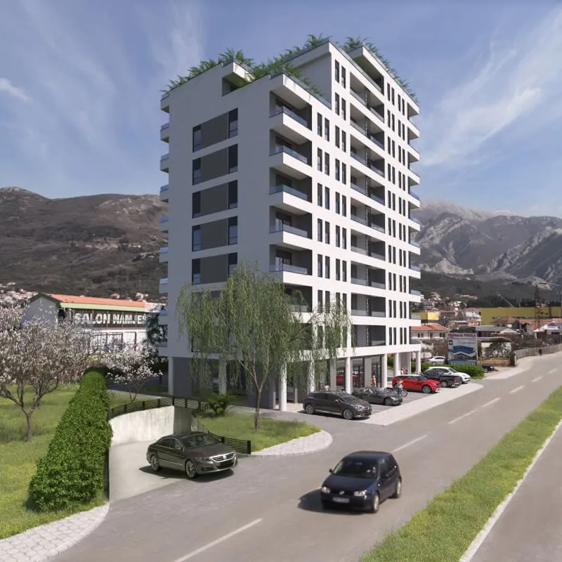 Exterior view of a multi-story white residential building with balconies, parked cars, and mountains.