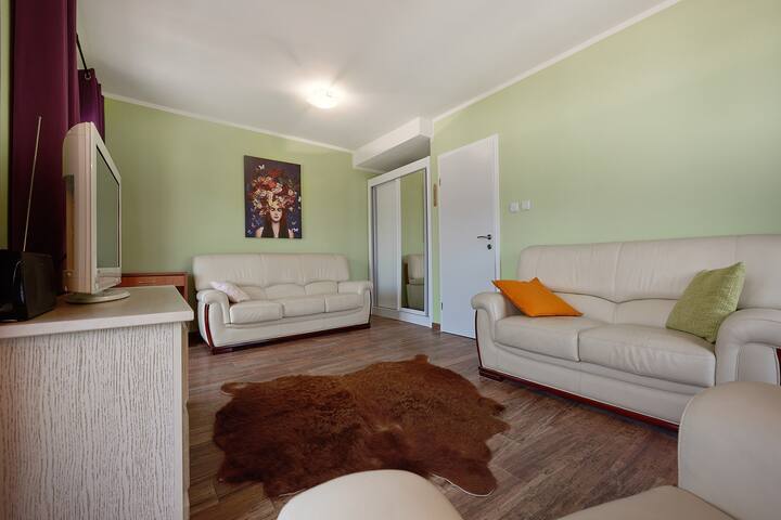 Living room with two white leather sofas and a fur rug in an apartment for sale in Prčanj, Montenegro.