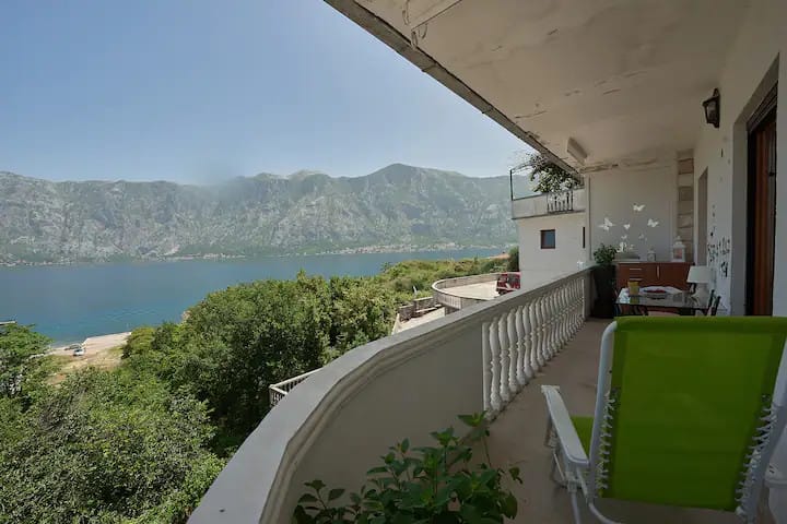 Balcony with panoramic views of Kotor Bay and the mountains in an apartment, Prčanj, Montenegro: terrace with garden furniture.