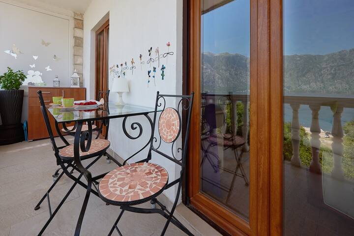 Cozy balcony with wrought-iron furniture and a view of the Bay of Kotor, apartment in Prčanj, Montenegro.
