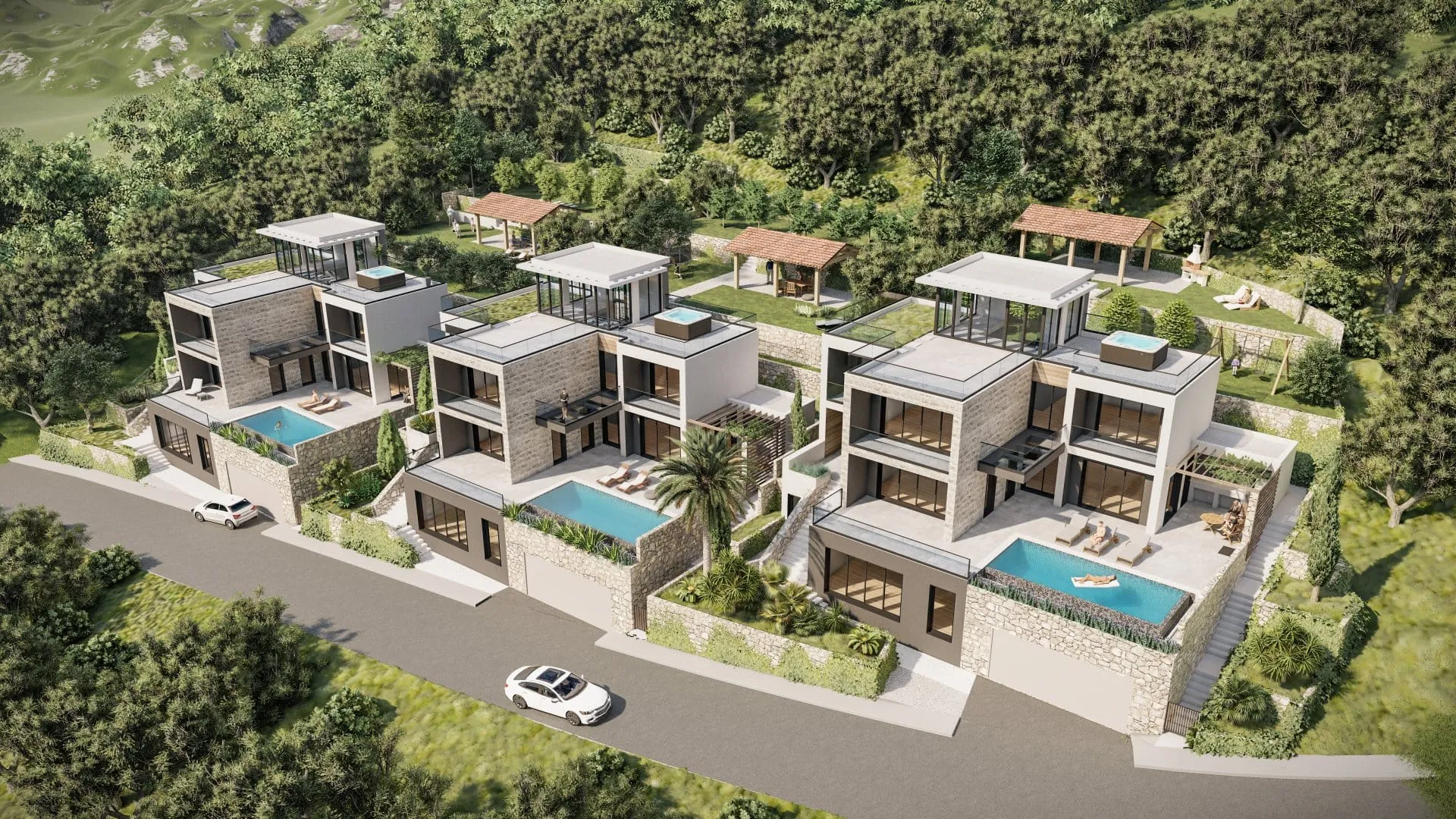 Aerial view of three modern villas with pools situated on a green hillside.