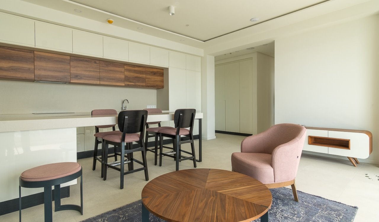 Modern living room with kitchen in an apartment in Bečići, Montenegro: stylish furniture, bright interior, and a lounge area.