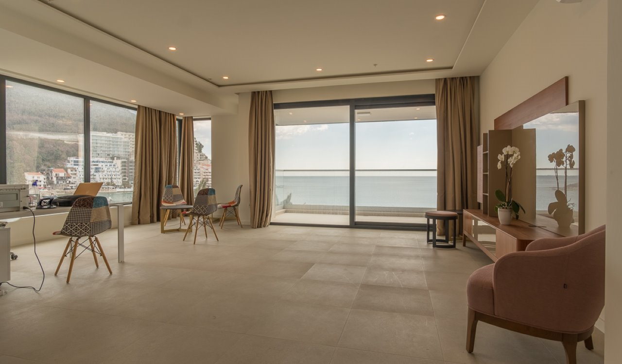 Spacious living room with panoramic sea and mountain views in an apartment, Becici, Montenegro: modern interior.