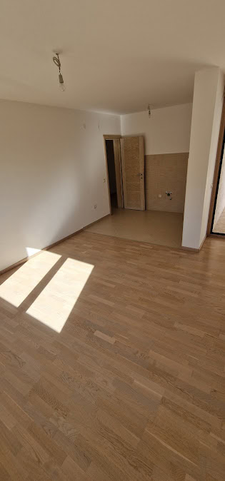 Bright living room with parquet in a new apartment in Becici, Budva Riviera, Montenegro, prepared for finishing.