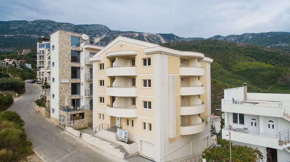 Modern residential complex with balconies in Becici, Budva Riviera, Montenegro: view of the building and mountains.