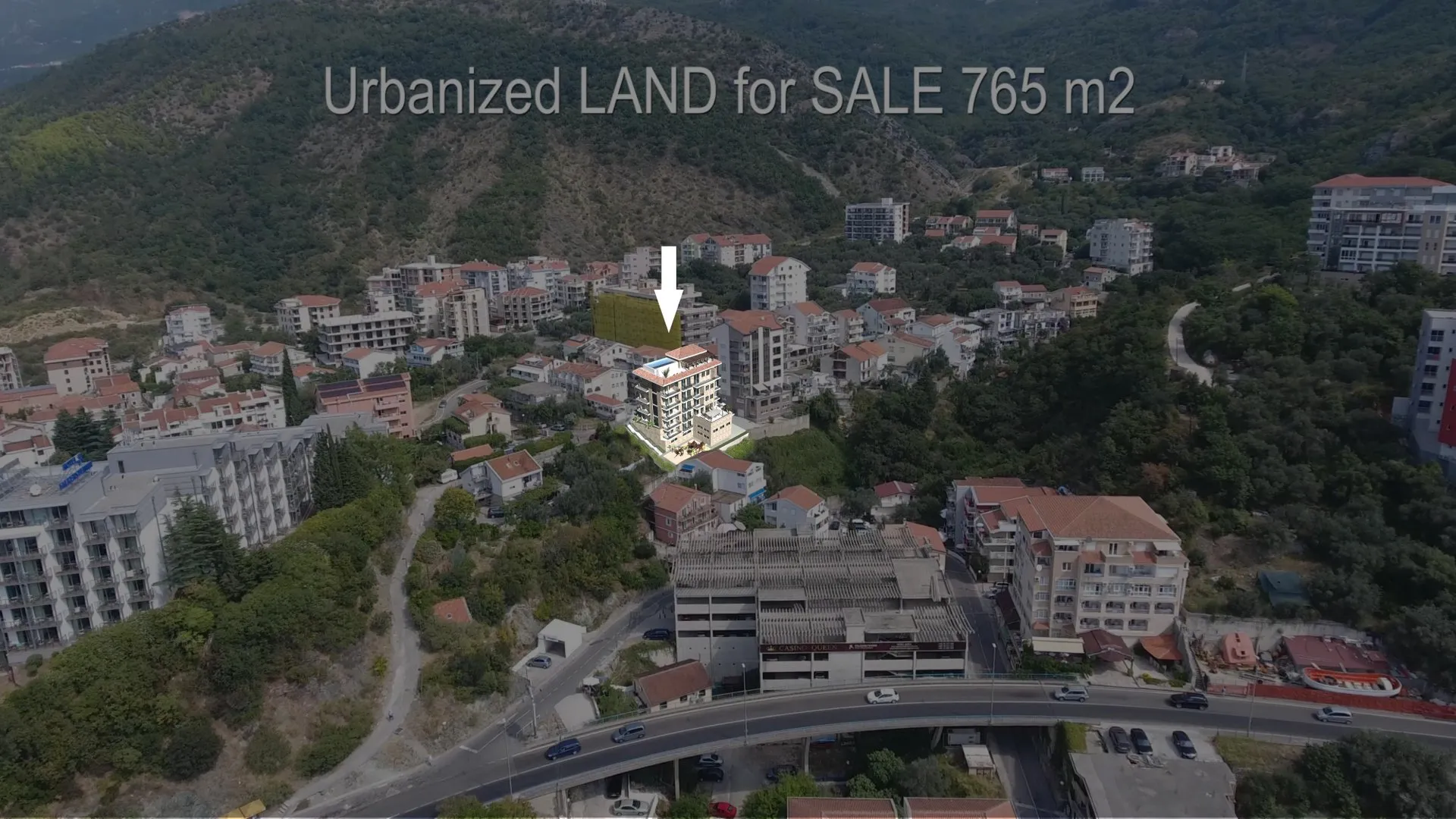 Aerial view of a residential area with mountains in the background and an arrow pointing to a specific building.