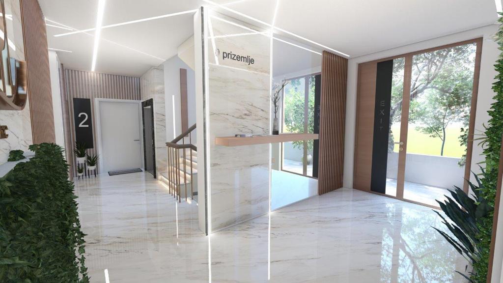 Modern lobby of a residential complex in Dobrota, Montenegro: marble finishes, stylish lighting, and interior greenery.