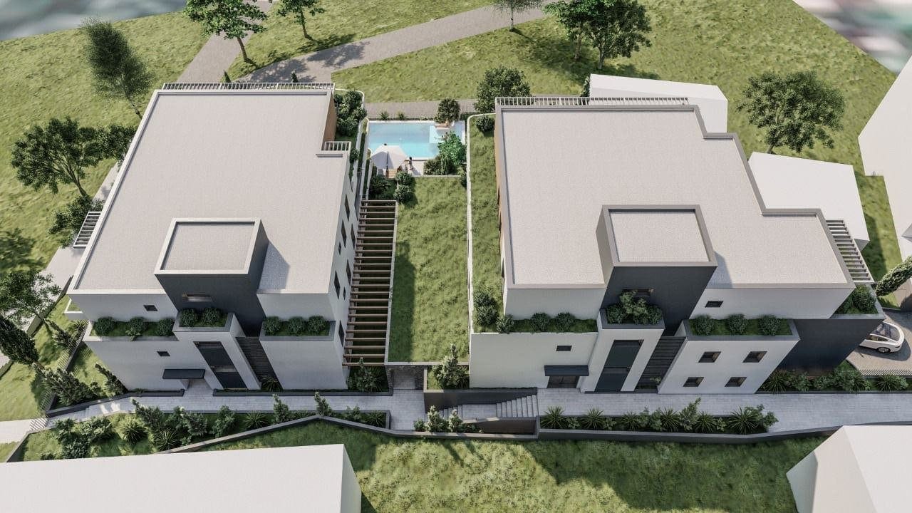 Aerial view of a residential complex in Dobrota, Montenegro: modern villas with a pool, terraces, and landscaped design.