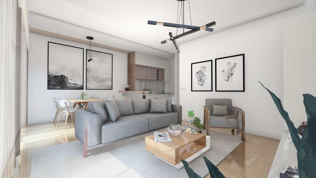 Modern living room with kitchen in the Dobrota residential complex, Montenegro: gray sofa, wooden coffee table, and stylish interior.