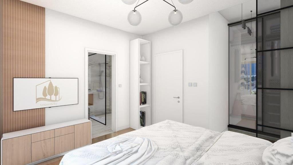 Modern bedroom in the Dobrota residential complex, Montenegro: bright interior, built-in wardrobe, TV area, and access to the bathroom.