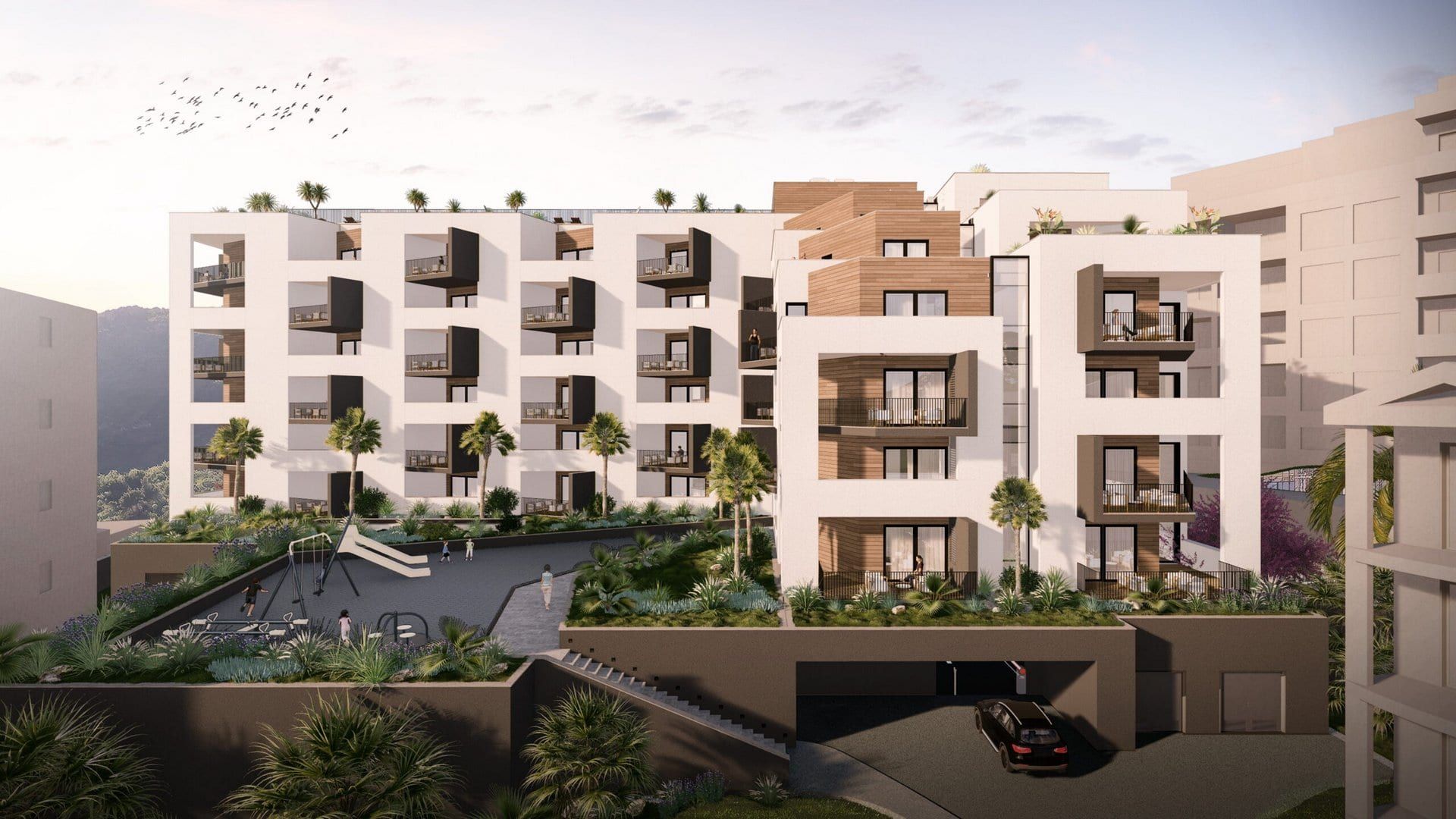 Modern residential complex in Bečići, Montenegro: facade with terraces, playground, and underground parking.