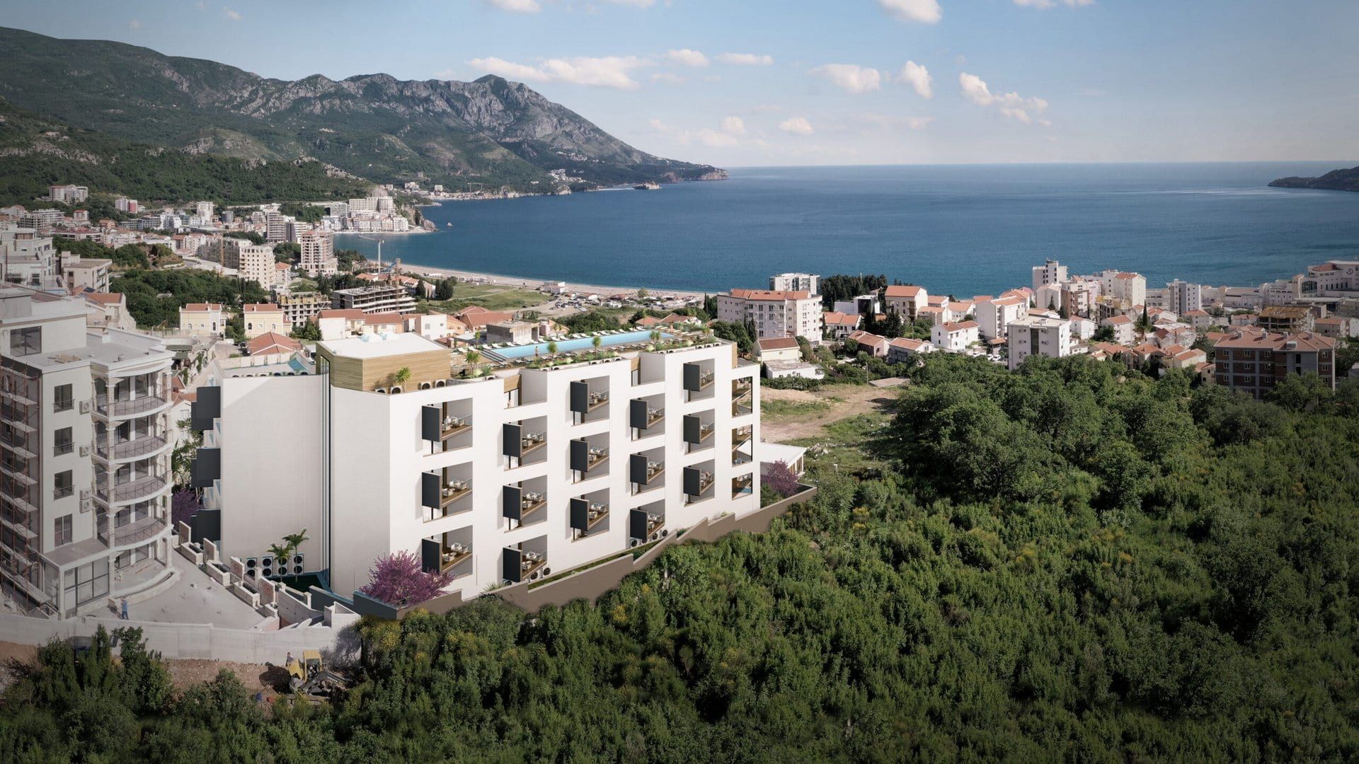 New residential complex in Bečići, Montenegro: a modern building with a rooftop pool and panoramic sea views.