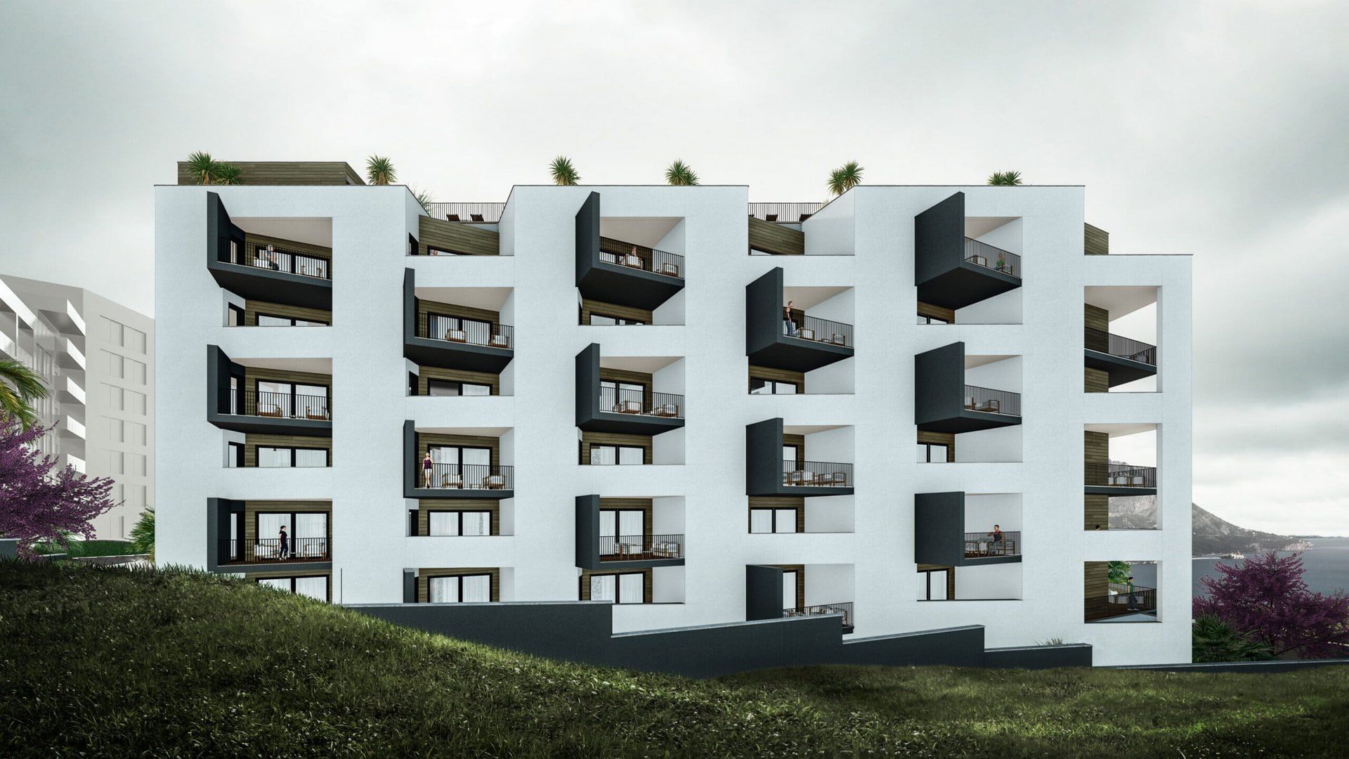 Modern residential complex in Bečići, Montenegro: building facade with terraces, panoramic windows, and sea view.