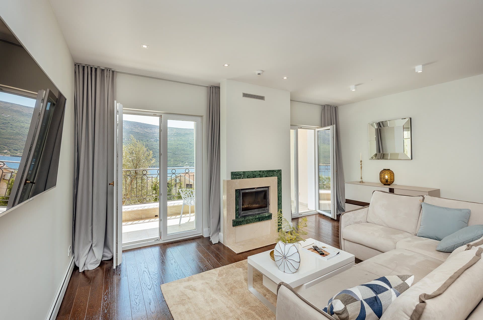 Living room with a fireplace and access to a terrace with sea views in a residential complex, Kumbor, Montenegro.