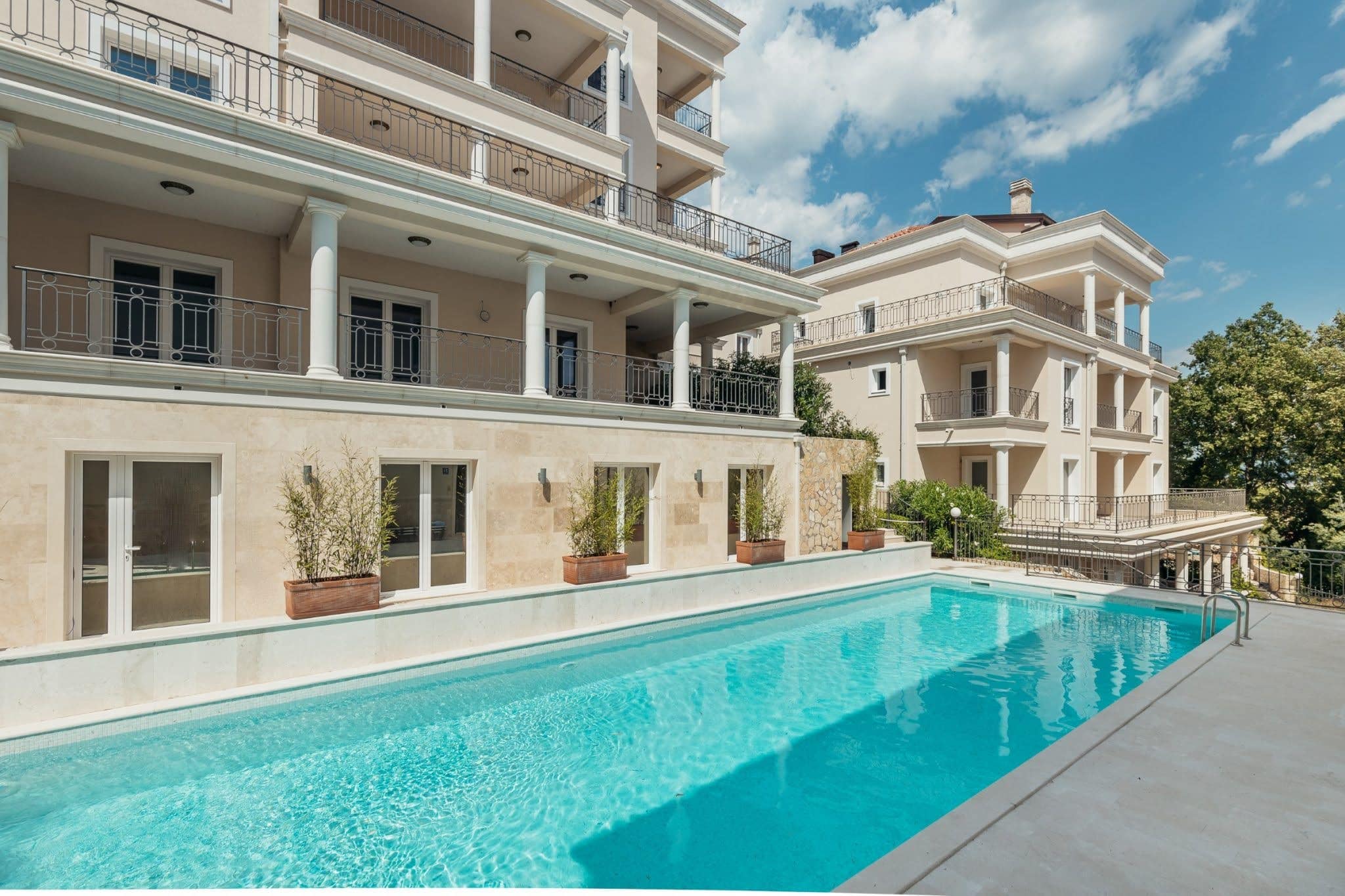 Pool at an upscale residential complex in Kumbor, Montenegro: a modern villa with terraces and a stone-clad facade.