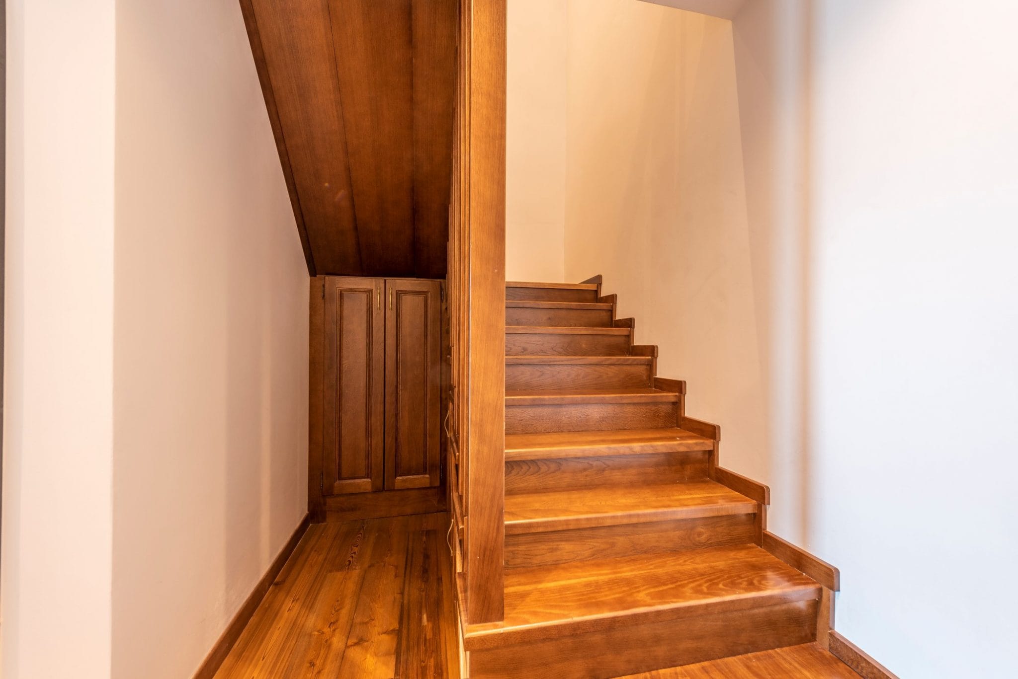 Wooden staircase with built-in closet in a penthouse interior in Bečići, Montenegro. High-quality wood finish.