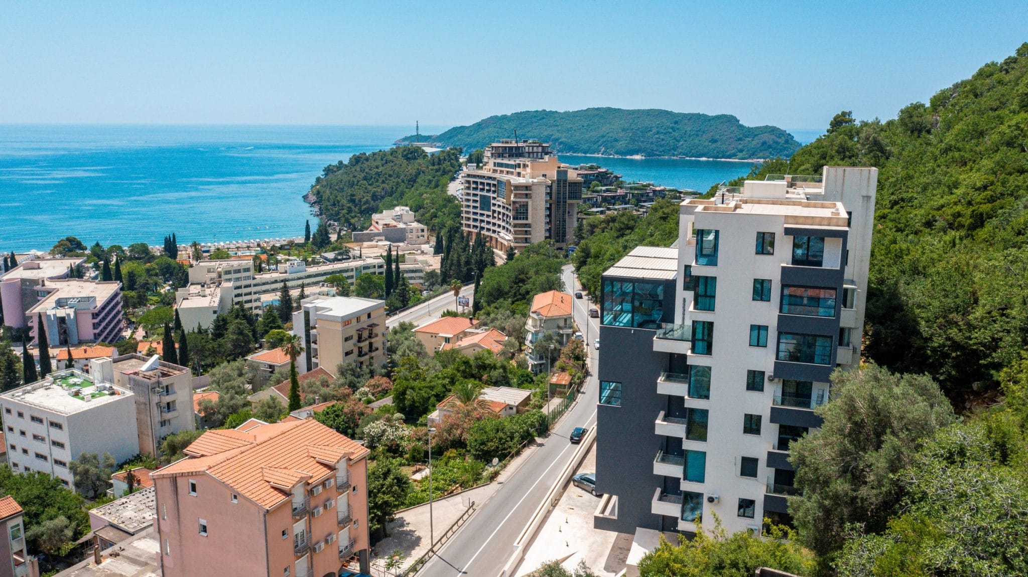 Aerial view of a modern residential complex in Bečići, Montenegro, with panoramic views of the sea and coastline.