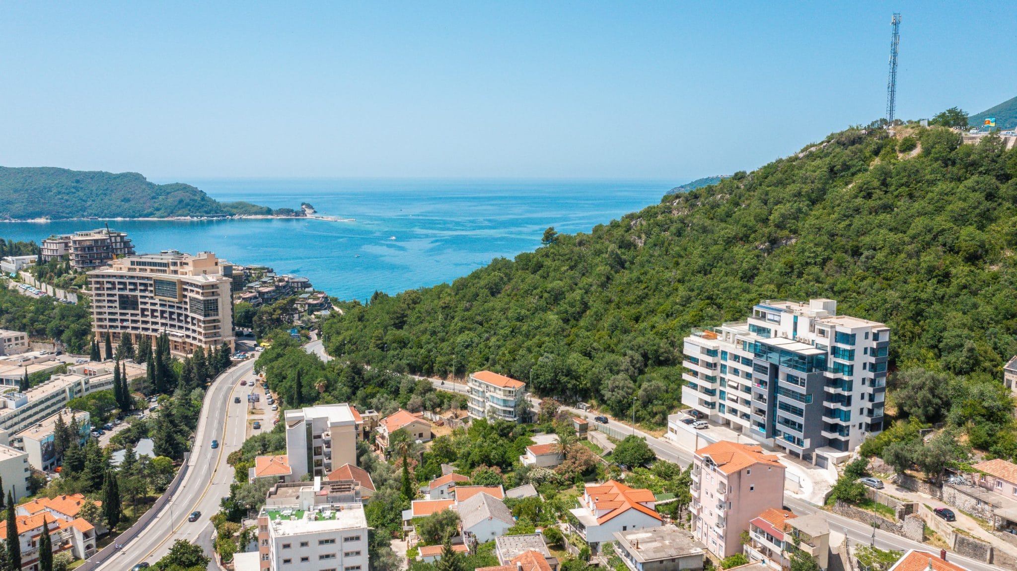 Panoramic sea and mountain view from a penthouse in Bečići, Montenegro: modern residential complexes and the Adriatic coast.