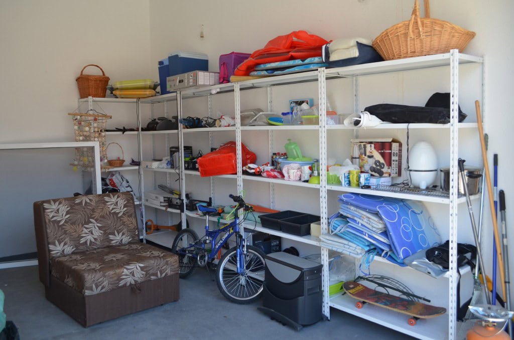 Storage room in an apartment in Bar, Montenegro: metal shelving with items, a bicycle, and an armchair for storage.