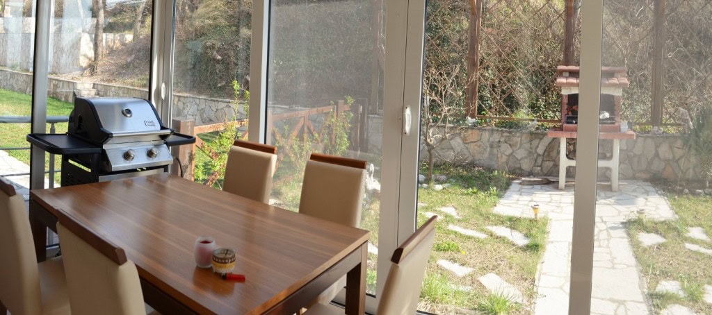 Living room with dining area and access to a terrace with a barbecue in an apartment, Bar, Montenegro.