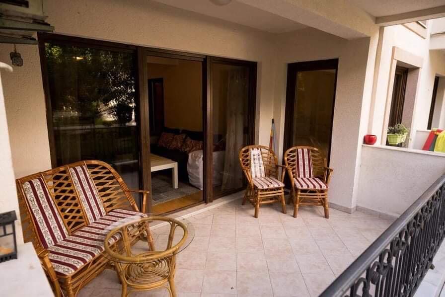 Cozy terrace with wicker furniture and panoramic windows in an apartment in Budva, Montenegro.